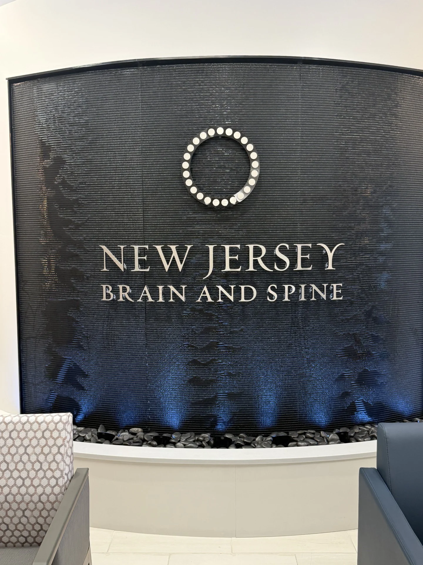 Curved black scored acrylic aquafall water wall with logo for new jersey brain and spine in paramus nj